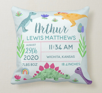Blue cushion for baby boy nursery, with colourful dinosaur and space to add birth stats